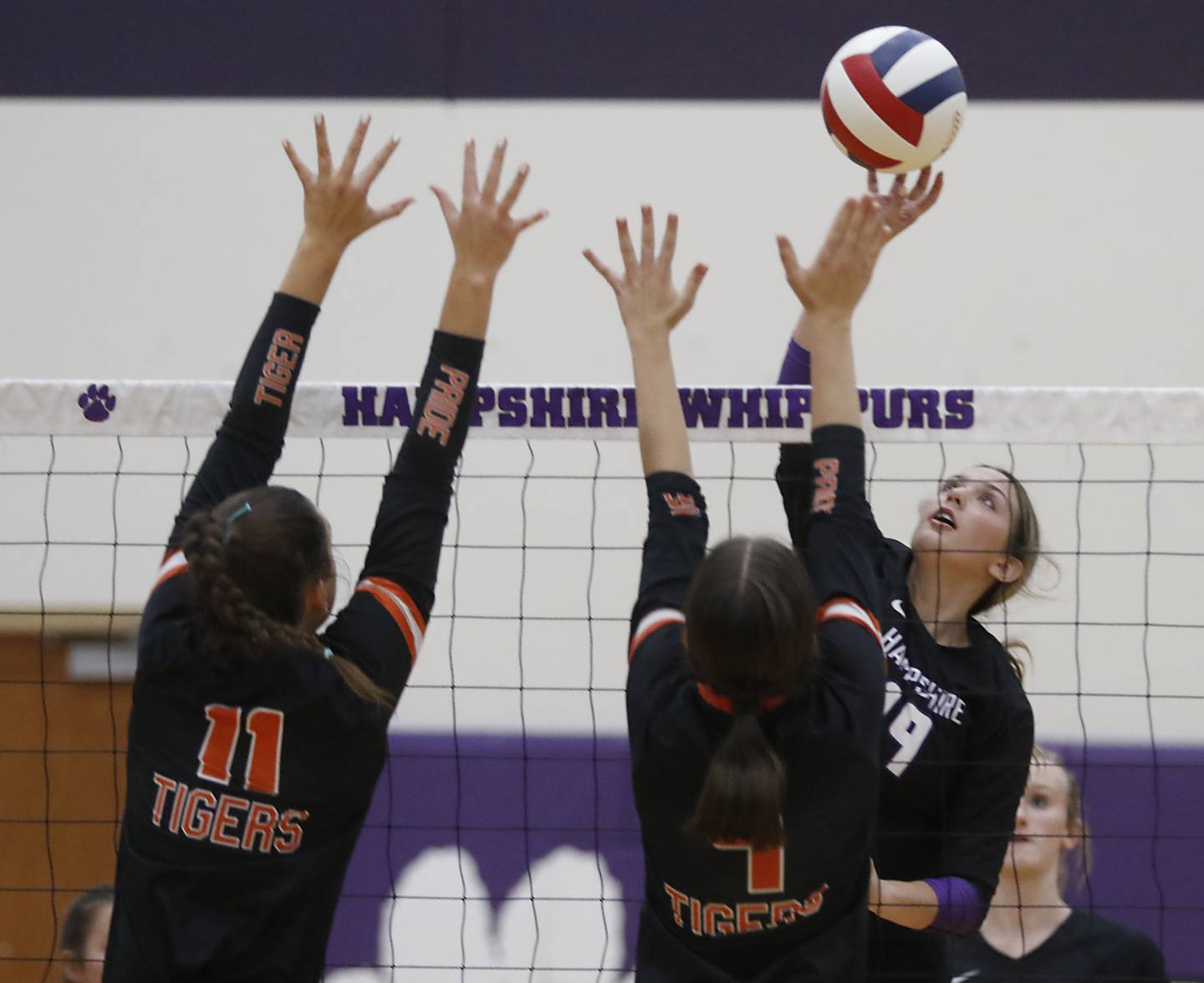 Hampshire's Katelyn Petterson (right) tries to hit the ball through the block of Crystal Lake Central's Emily Mazza (left) and Martina Tam (center) during a Fox Valley Conference volleyball match on Tuesday, Sept. 24, 2024, at Hampshire High School.