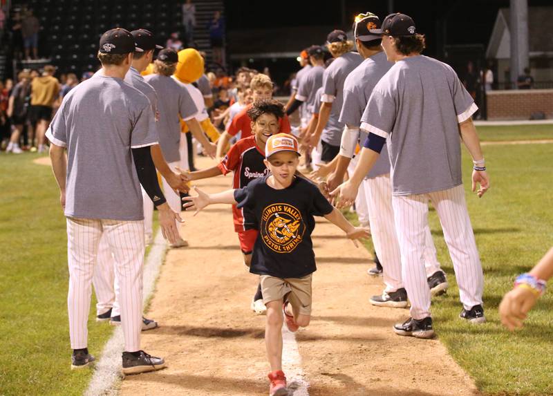 Hundreds of children run the bases while giving players hi-fives after the Prospect League Championship on Wednesday, Aug. 7, 2024 at Schweickert Stadium in Peru.