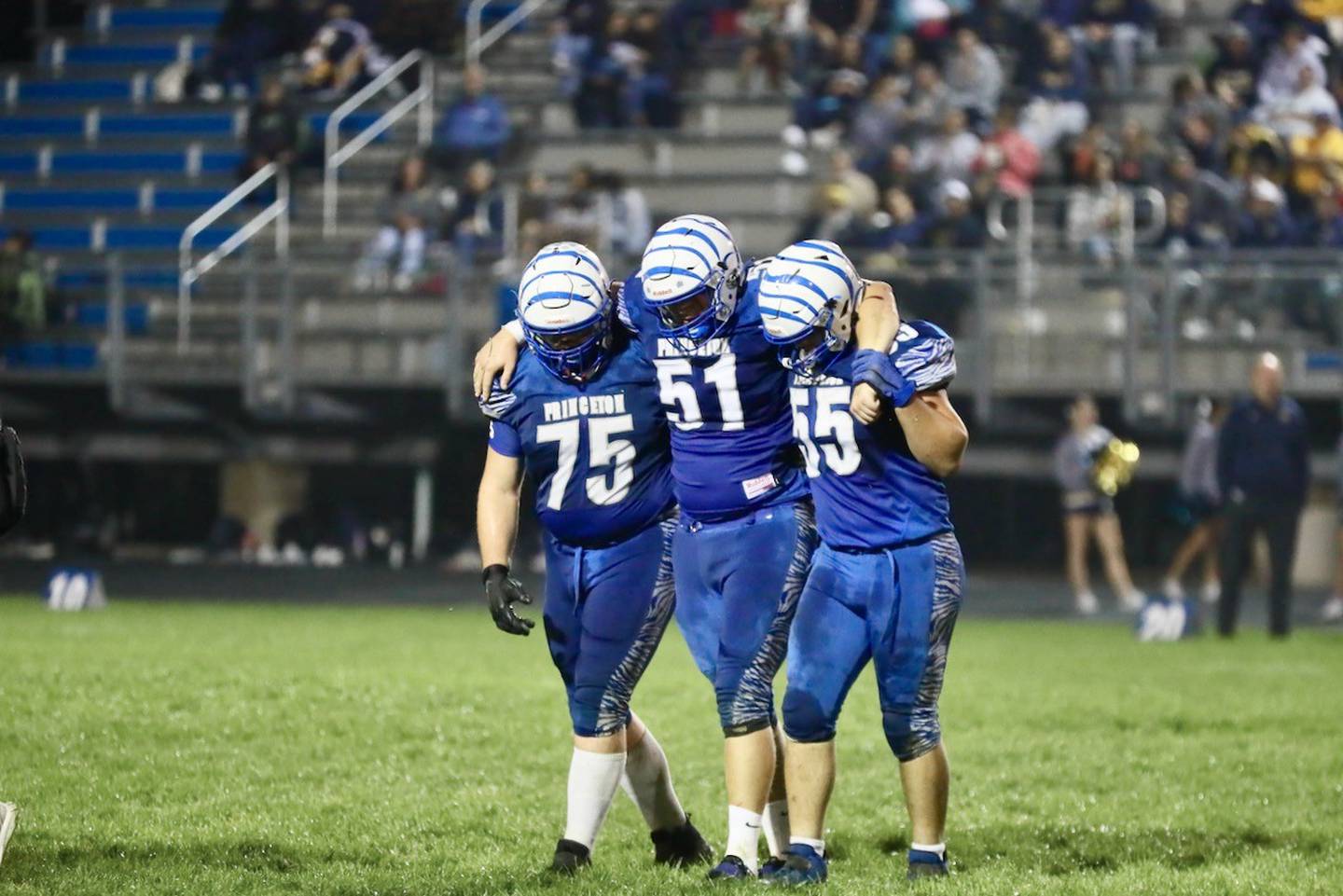 Princeton senior Bennett Williams (51) is helped off the field by teammates Payne Miller (75) and Jack May (55) after injuring his knee Friday night.