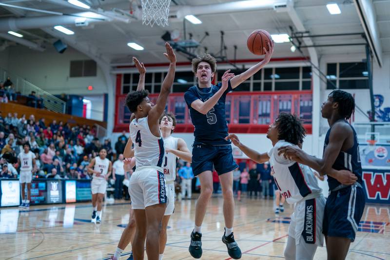 Oswego East's Mason Blanco (5) shoots the ball in the post against West Aurora's Joshua Pickett (4) during a basketball game at West Aurora High School on Friday, Jan 27, 2023.
