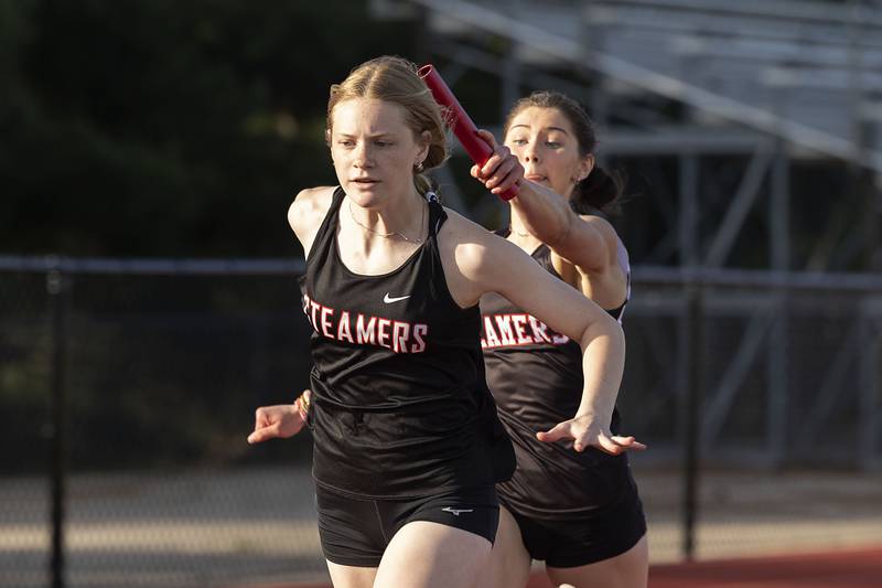 Fulton’s Brooklyn Thoms reaches out with the baton to teammate Haley Smither in the 4x100 Wednesday, May 10, 2023 at the class 1A Erie girls track sectional.