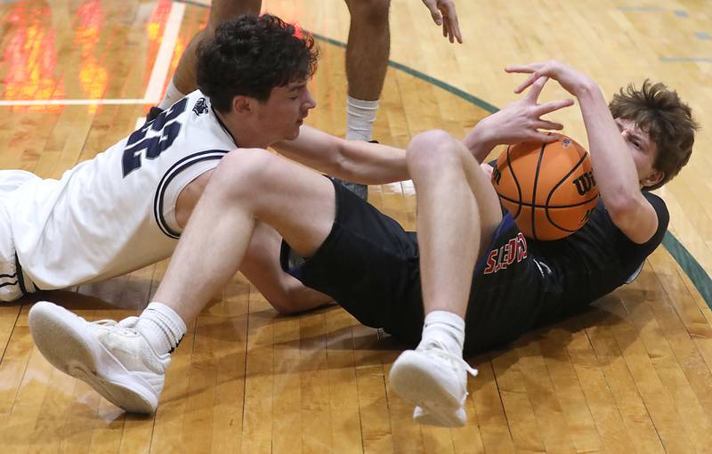 Cary-Grove's Adam Bauer battles with Marmion's Colin McEniry for a loose ball during an IHSA Class 3A Crystal Lake South Regional boys basketball semifinal game on Wednesday, February, 25, 2026, at Crystal Lake South High School.