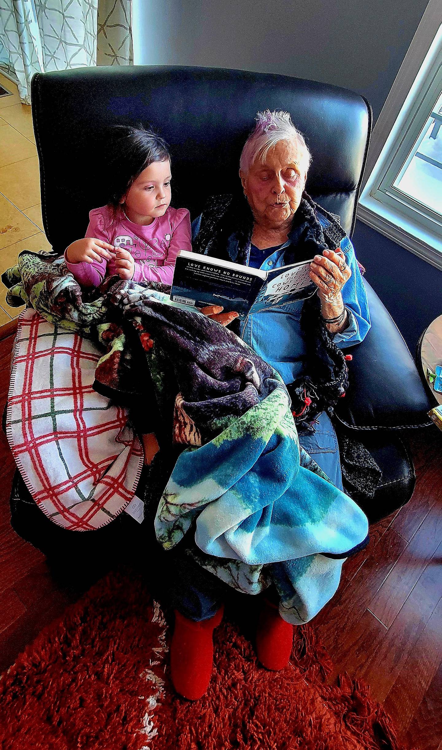 Jo Dergo reads a book to Amy Phillips’ 4-year-old niece Lilliegh Jane dubbed L.J.