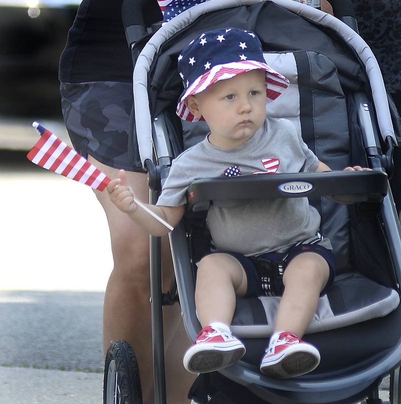 Barrett Reeve holds onto his flag Monday, May 30, 2022, as he watches the annual Memorial Day parade march along Columbus Street in Ottawa.