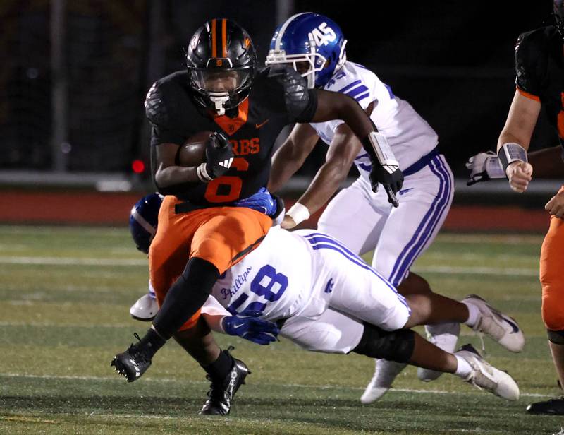 DeKalb's Travis Moore tries to break free from Phillips' Khalib Billingslea Friday, Sept. 5, 2025, during their game at DeKalb High School.