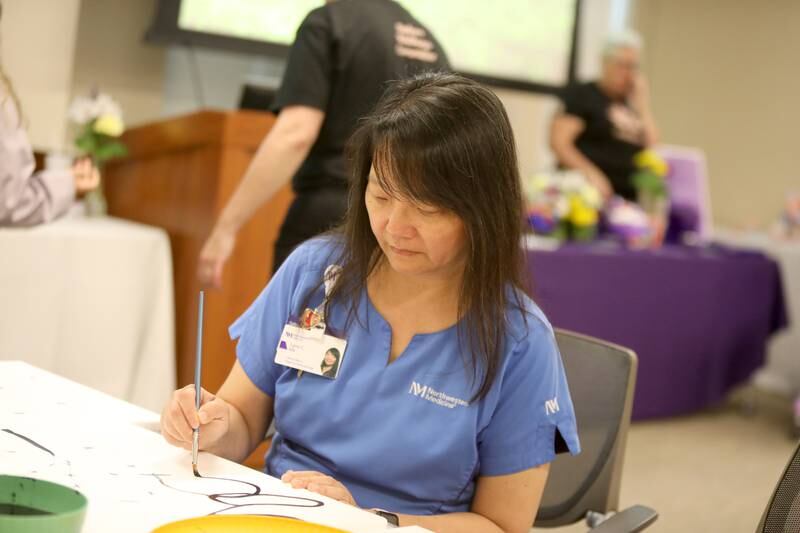 Registered Nurse Lynn Chen-Molina paints part of what will be a larger mural during Wellness Wednesday as part of Nurses Week at Northwestern Medicine Delnor Hospital on Wednesday, May 8, 2024 in Geneva.
