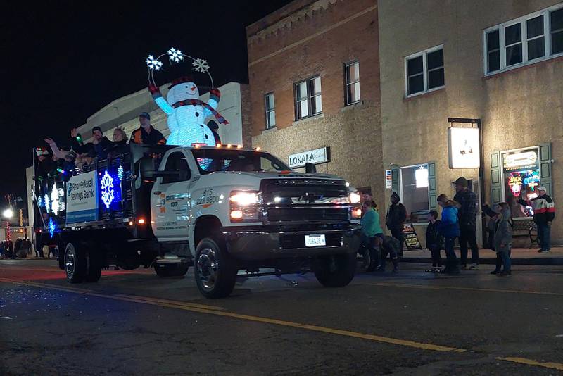A wintry parade float from Peru Federal Savings Bank makes its way Saturday, Dec. 2, 2023, along the Lighted Christmas Parade route in Peru.