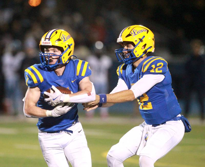 Lyons Township’s Danny Carroll gets the hand-off from quarterback Dominic Pisciotti during the Class 8A second-round game against Downers Grove South on Friday, Nov. 8, 2024 at Lyons Township in Western Springs.