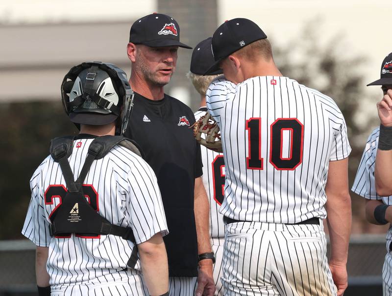 Fulton head coach Brent Dykstra comes out to settle down his pitcher Dom Kramer Monday, June 2, 2025, during their Class 1A supersectional game against Marquette at Northern Illinois University in DeKalb.