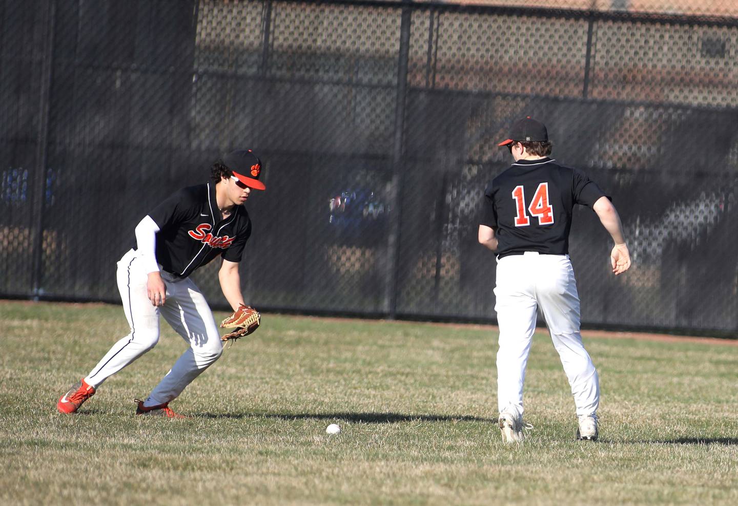 Wheaton Warrenville South’s John Jensen (left) and Corey Gul scramble for a dropped pop fly in the outfield during a game at St. Charles North on Monday, April 10, 2023.