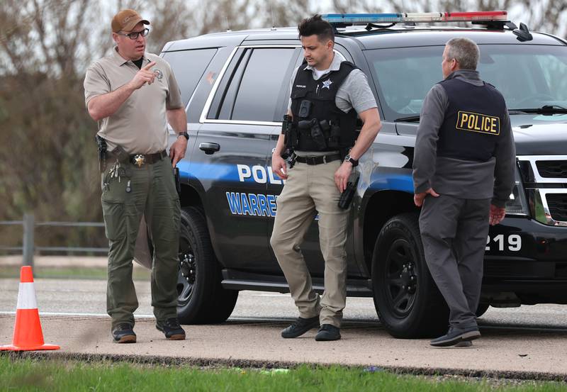 Law enforcement officials talk near a Honda sedan with a shattered window in the westbound lanes of Interstate 88 Monday, April 27, 2026, as they investigate an incident on I-88 just west of Keslinger Road in Maple Park.