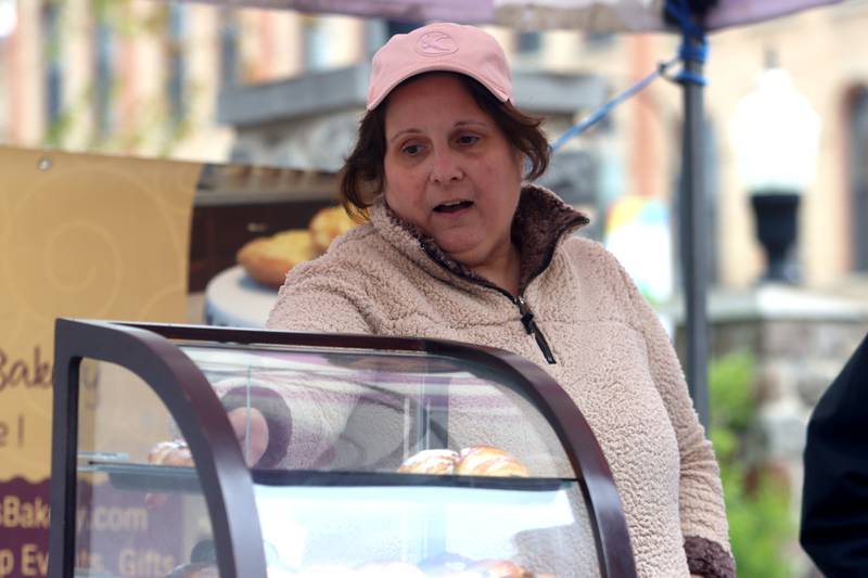 Bridget Welsch sells croissants at the Bridge N Sweets booth during the farmers market Saturday, April 29, 2023, on the historic Woodstock Square.