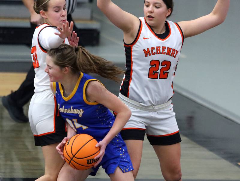 McHenry’s Lucy Jones, left, and Brooklyn Anderson, right, guard Johnsburg’s Summer Toussaint in varsity girls basketball on Saturday, Jan. 4, 2025, at McHenry High School in McHenry.