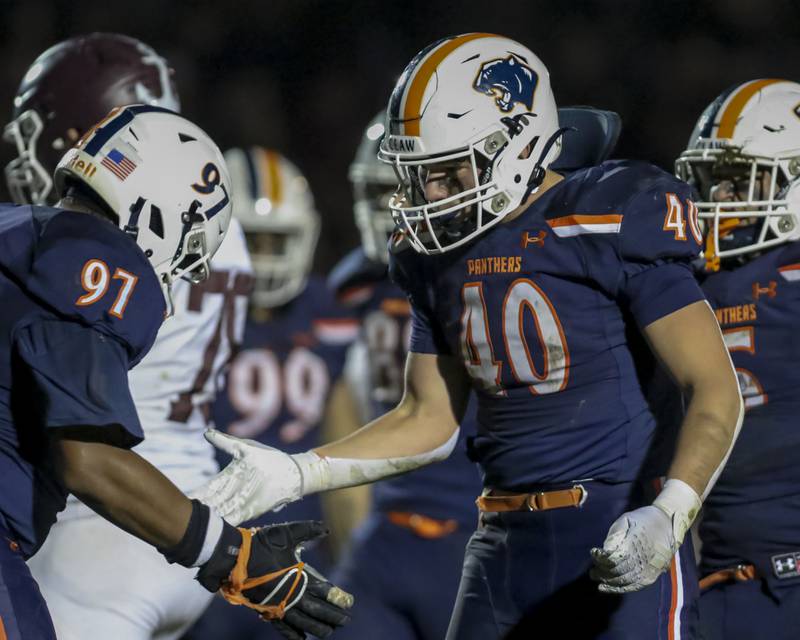 Oswego's Conor Tully (40) celebrates a tackle with Andrew Shaw (97) during Class 8A semifinal football game between Lockport at Oswego. Saturday, Nov 22, 2025 in Oswego.
