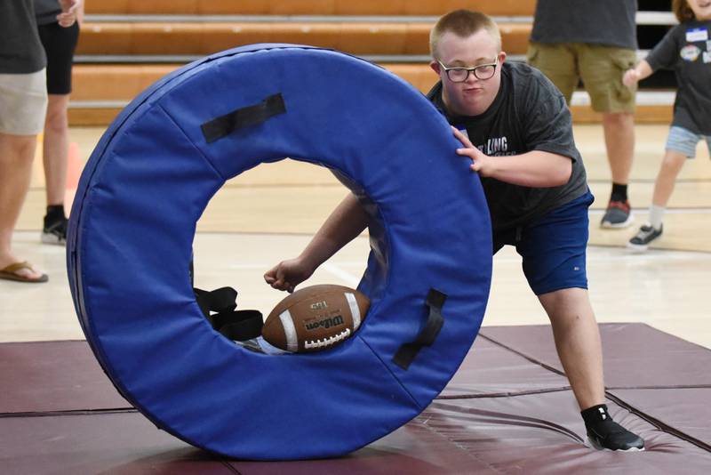 Evan Hudson punches at the ball during a drill at Watseka's Tackling Disabilities football camp Saturday, July 26, 2025.