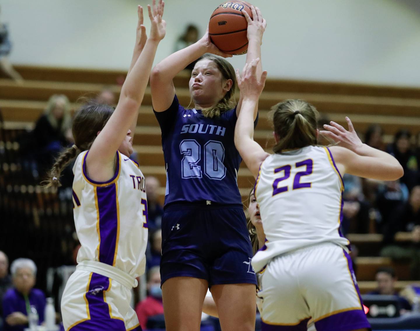 Downers Grove South’s Megan Ganschow (20) puts up a shot against Downers Grove North’s Anne Stephens (31) and Maggie Fleming (22) during a Class 4A Downers Grove South Regional semifinal in Downers Grove, Ill. on Monday, Feb. 13, 2023.