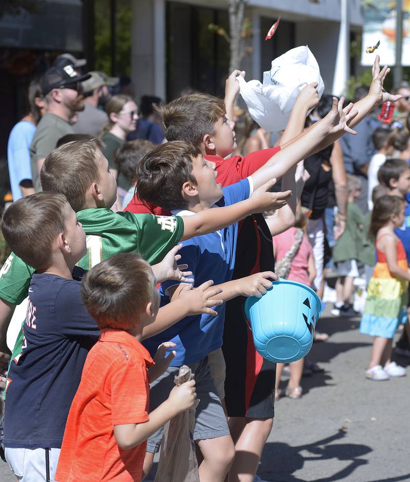 Children reach for canned trees thrown their way along LaSalle St  Ottawa Sunday during the Fall Fest Parade.