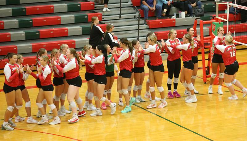 Members of the L-P volleyball team celebrate after defeating Kaneland on Tuesday, Oct. 7, 2025 in Sellett Gymnasium at L-P High School.