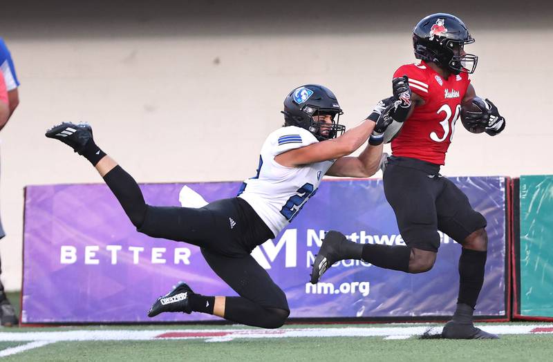 Northern Illinois Huskies running back Harrison Waylee gets pushed out of bounds after a big gain by Eastern Illinois Panthers safety Kaelin Drakeford during their game Thursday, Sept. 1, 2022, in Huskie Stadium at NIU.