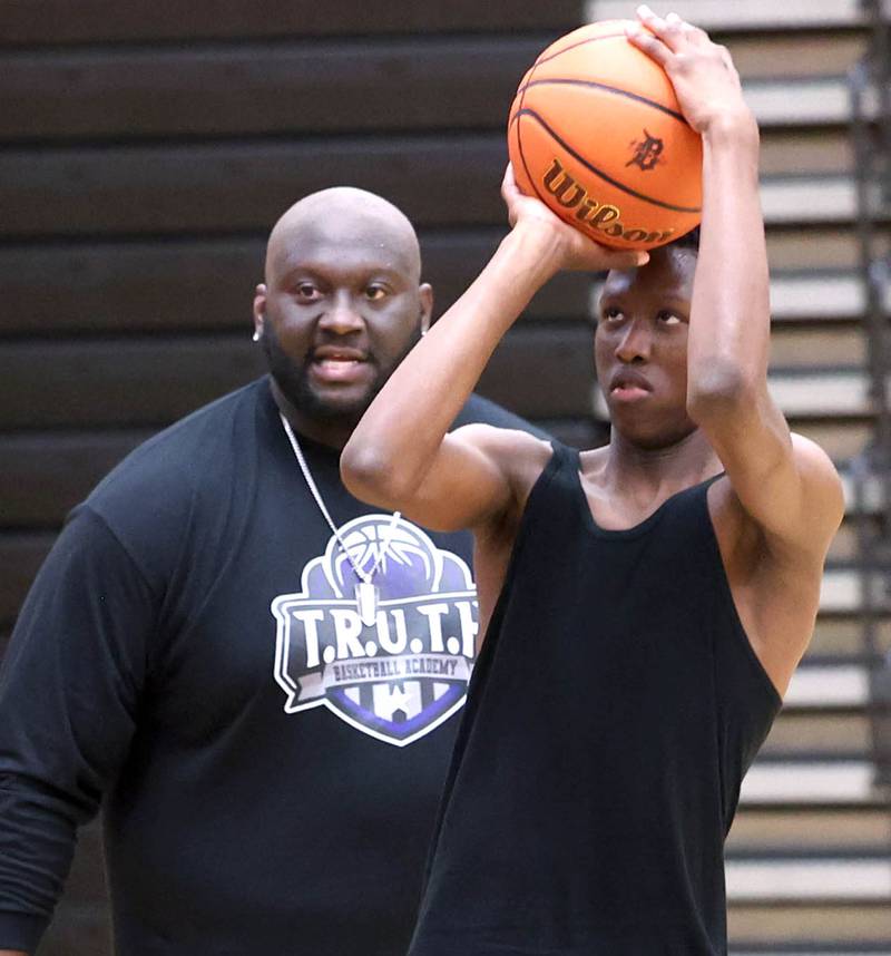 Jay Moore, founder of TRUTH Basketball Academy and an assistant basketball coach at DeKalb High School, gives some coaching to Gabe Crump, 15, from DeKalb, as he shoots a jump shot Tuesday, June 25, 2024, during a session at the school.
