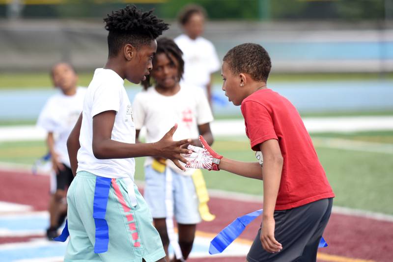 Lawrence Willett, 12, of Kankakee, left, is congratulated by fellow 12-year-old Kankakee resident Alvion Floyd during a game of 7-on-7 at the sixth annual Jonathan Ward Skills Camp Saturday, June 14, 2025.