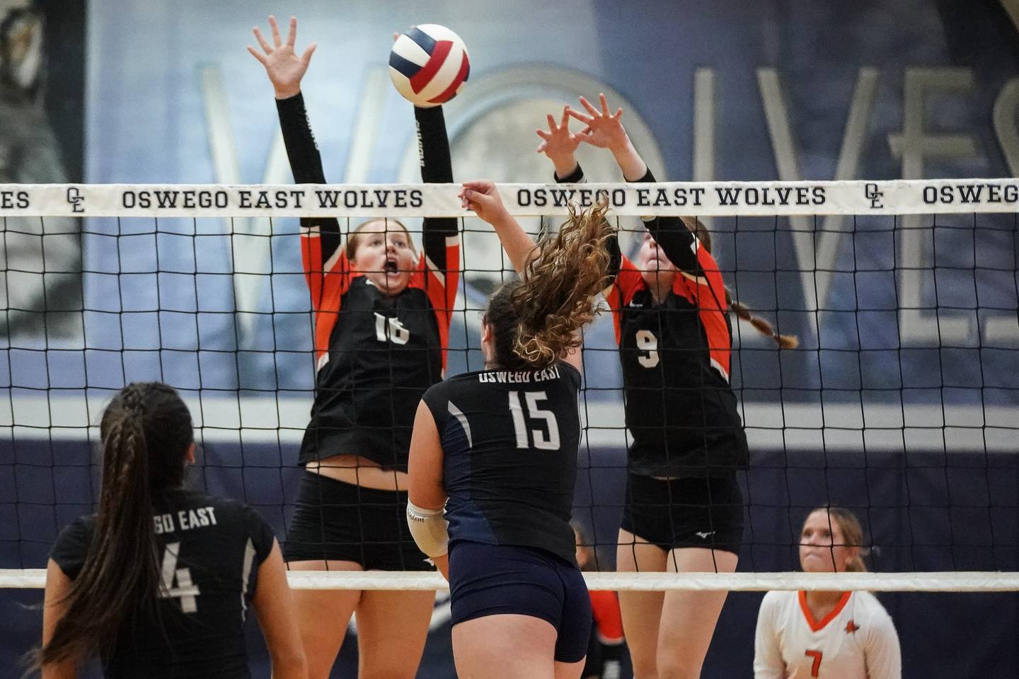 Minooka’s Lily Mayer (16) and Charlotte Matejka (9) defend the net against a kill attempt by Oswego East's Mia Stanley (15) during a Southwest Prairie Conference match in Oswego on Thursday, Sept. 18, 2025.