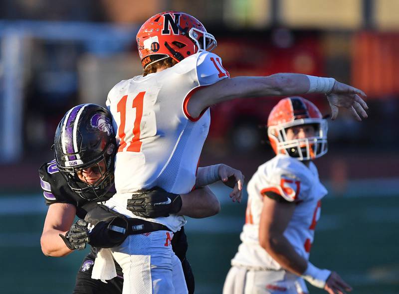 Downers Grove North's Carter Chavez-Jimenez just misses sacking Normal Community quarterback Kyle Beaty (11) during an IHSA Class 7A semifinal game on Nov. 18, 2023 at Downers Grove North High School in Downers Grove .