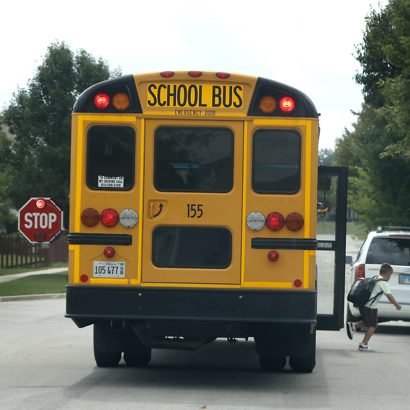 A child gets off a stopped Woodstock school bus on Sweetwater Drive in Woodstock on Thursday, Aug. 17, 2023.