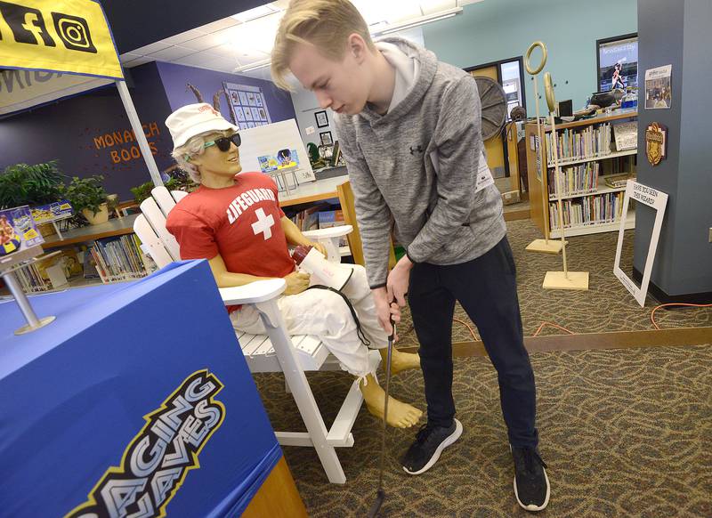 Chase Lackey, 14 of Millbrook, putts around an animatronic lifeguard on a hole sponsored by Raging Waves during the Friends of the Yorkville Library's annual Mini Golf FUN Raiser on Sunday Feb. 5, 2023.