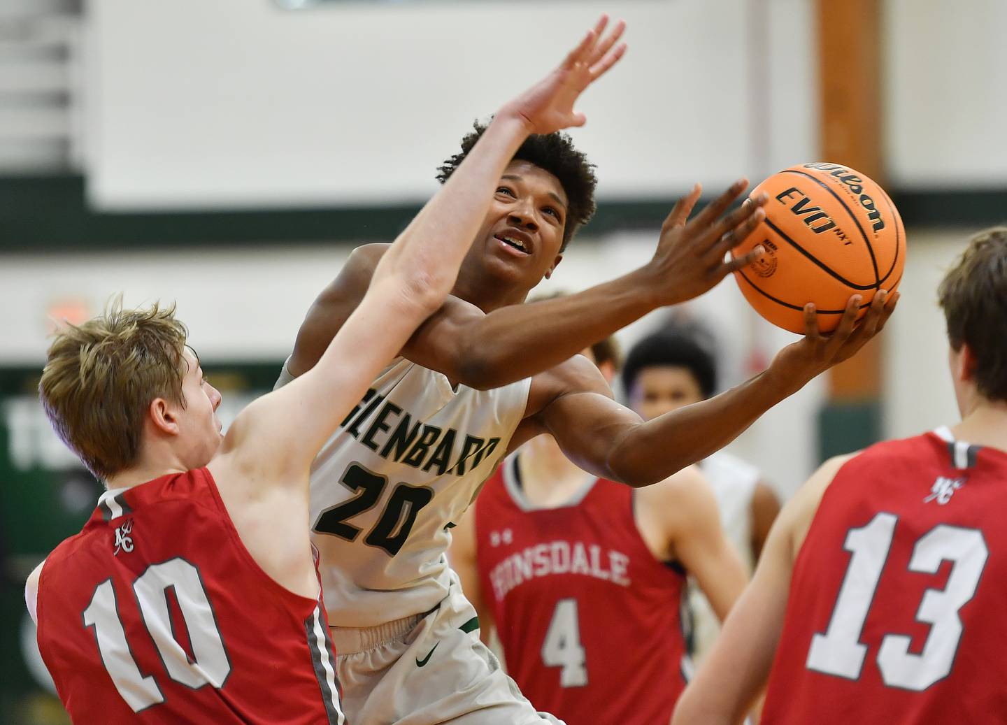 Glenbard West’s Logan Glover (20) puts the ball up as Hinsdale Central’s Tyler Thick (10) defends during a game on January 31, 2025 at Glenbard West High School in Glen Ellyn.