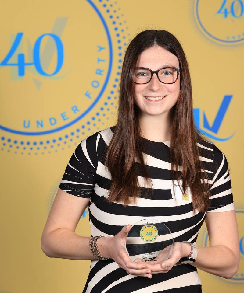 Sydney Kasperski poses with her 40 Under Forty award during the Illinois Valley Chamber of Commerce Champions of Change Awards Night on Thursday, April 10, 2025 at the Westclox Event Center in Peru.