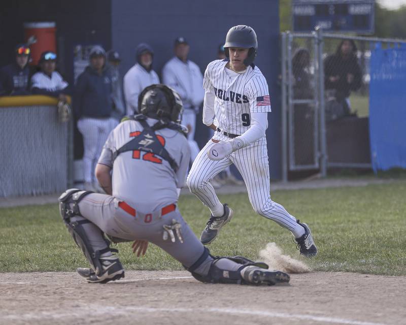 Oswego East's Mason Palermo (9) looks for sliding room before being tagged out at the plate during baseball game between Oswego East at Oswego. Monday, May 19, 2025 in Oswego.