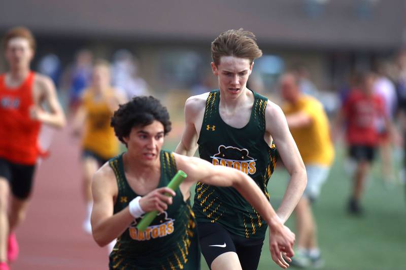 Crystal Lake South’s Joseph Gonzalez, right, hands off to Chad Wehby in the 3200-meter relay in Fox Valley Conference boys track and field meet action at Huntley High School in Huntley on Thursday, May 15, 2025.