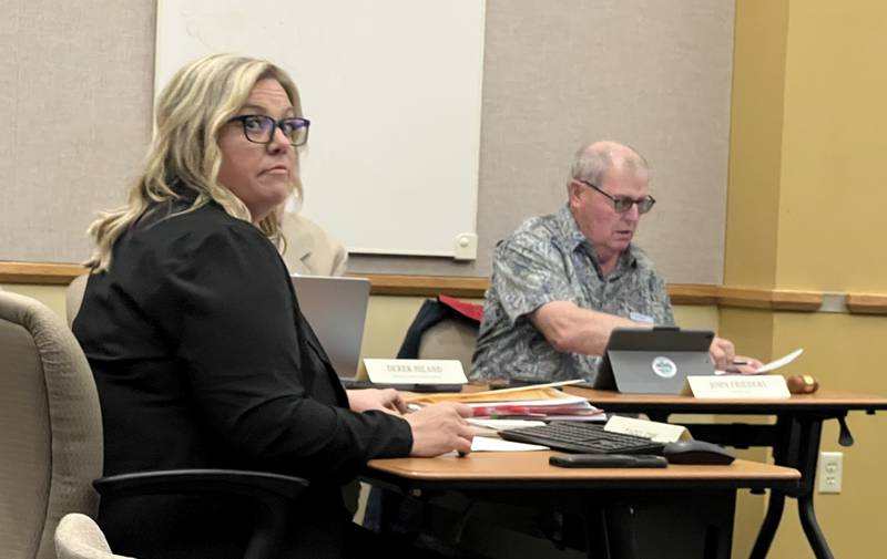 DeKalb County Clerk and Recorder Tasha Sims looks to the podium during the DeKalb County Board meeting on May 21, 2025, while DeKalb County Board Chairman John Frieders looks through county documents.