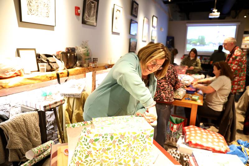 Jacki Quirin wraps a gift during a gift wrapping party for clients of the Association for Individual Development (AID) hosted by the Batavia Rotary Club on Thursday, Dec. 12, 2024 at Brother Chimp Brewing in North Aurora.