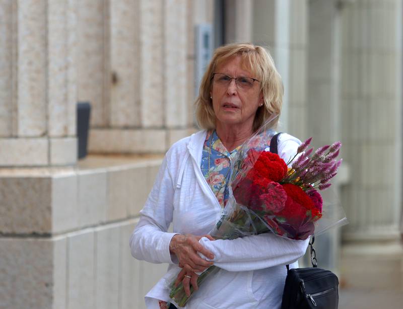 Tricia Schafer of Crystal Lake clutches a bouquet of flowers she purchased during the Johnny Appleseed Festival in downtown Crystal Lake on Saturday Sept. 28, 2024, in Crystal Lake.