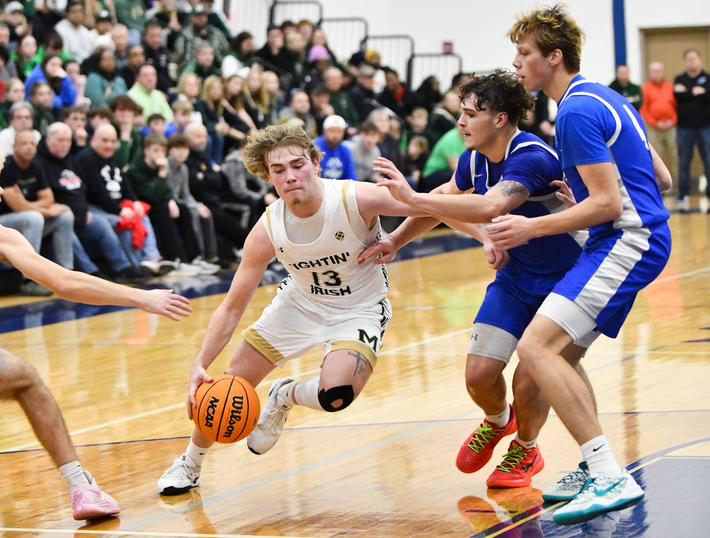 Bishop McNamara's Trey Provost drives to the basket under pressure from Bismarck-Henning's Micah Stanford and Chaz Dubois during the Fightin' Irish's 52-49 loss in the IHSA Class 2A Peotone Sectional championship on Friday, March 7, 2025.