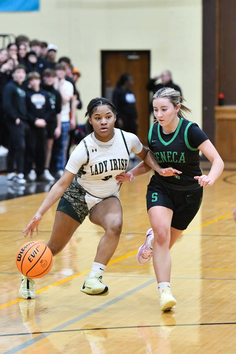 Bishop McNamara's Eliana Isom drives toward the lane against Seneca's Alyssa Zellers during the Fightin' Irish's 51-30 victory over Seneca in the IHSA Class 2A Herscher Sectional semifinal on Tuesday, Feb. 25.