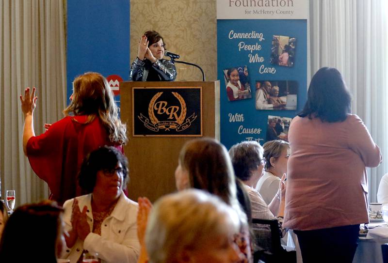 Kathleen Caldwell, of Caldwell Consulting Group, leads applause for past winners of the Women of Distinction award during the Northwest Herald's Women of Distinction award luncheon Wednesday June 29, 2022, at Boulder Ridge Country Club, 350 Boulder Drive in Lake in the Hills. The luncheon recognized 10 women in the community as Women of Distinction plus Lisa Hoeppel as the first recipient of the Kelly Buchanan Woman of Inspiration award. The award is named for Buchanan, who came up with the Women of Distinction idea, launched 10 years ago in the May 2010 edition of McHenry County Magazine.