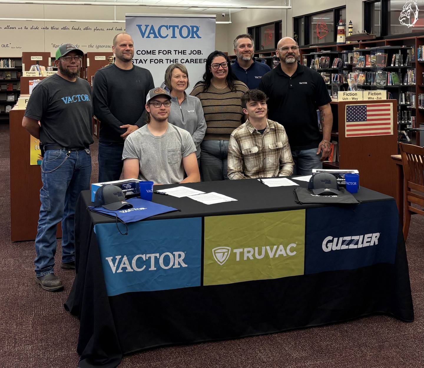 Streator High School seniors Jaxin Goodrich (left) and Aaron Henson (right) pose for a photo with Vactor Manufacturing representatives after signing their letters of intent on Tuesday, May 20, at Streator High School.