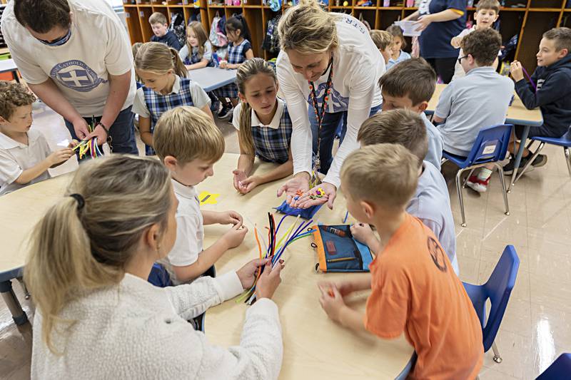 St. Anne’s principal Talarie Bilharz hands out crosses for handmade Rosaries Thursday, Oct. 12, 2023, at the school.