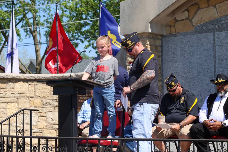 Dixie Norton, 8, of Clifton, welcomes attendees with assistance from her dad, Bradley American Legion Commander Corey Norton, and a chair, during the Legion's Memorial Day ceremony on Monday, May 25, 2026.