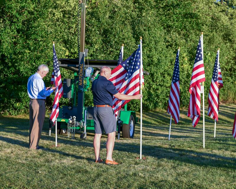 La Grange Village President Mark Kuchler, right, and retired U.S. Air Force Maj. General Tim McMahon retiring the colors and placing the last two flags of the 500 American flags on display at Denning Park in La Grange to honor veterans, active military, first responders as well as frontline workers.