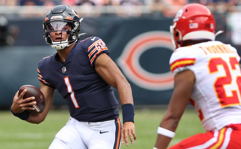 Chicago Bears quarterback Justin Fields picks up yardage on a scramble before sliding down in front of Kansas City Chiefs safety Juan Thornhill during their preseason game Sunday, Aug. 13, 2022, at Soldier Field in Chicago.