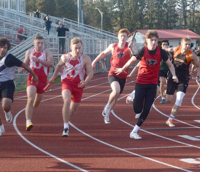 Oregon's Gabe Eckerd hands the baton to Emmett Peterson and Erie-Prophetestown Hunter Bruakota hands off to Jack Minson in an exchange of the 4x100 relay at the Oregon Hawk Classic in Oregon on Friday, April 28.