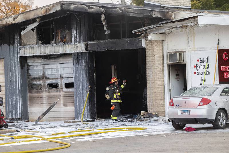 A firefighter checks for hot spots Friday, Nov. 7, 2025, at C&K Undercar Specialists in Sterling.
