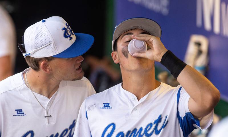 Newman Central Catholic first baseman Drake Cole talks to pitcher pitcher Evan Bushman while he hydrates in between innings during a game against Hope Academy at Northwestern Medicine Field in Geneva on Monday, June 2, 2025.