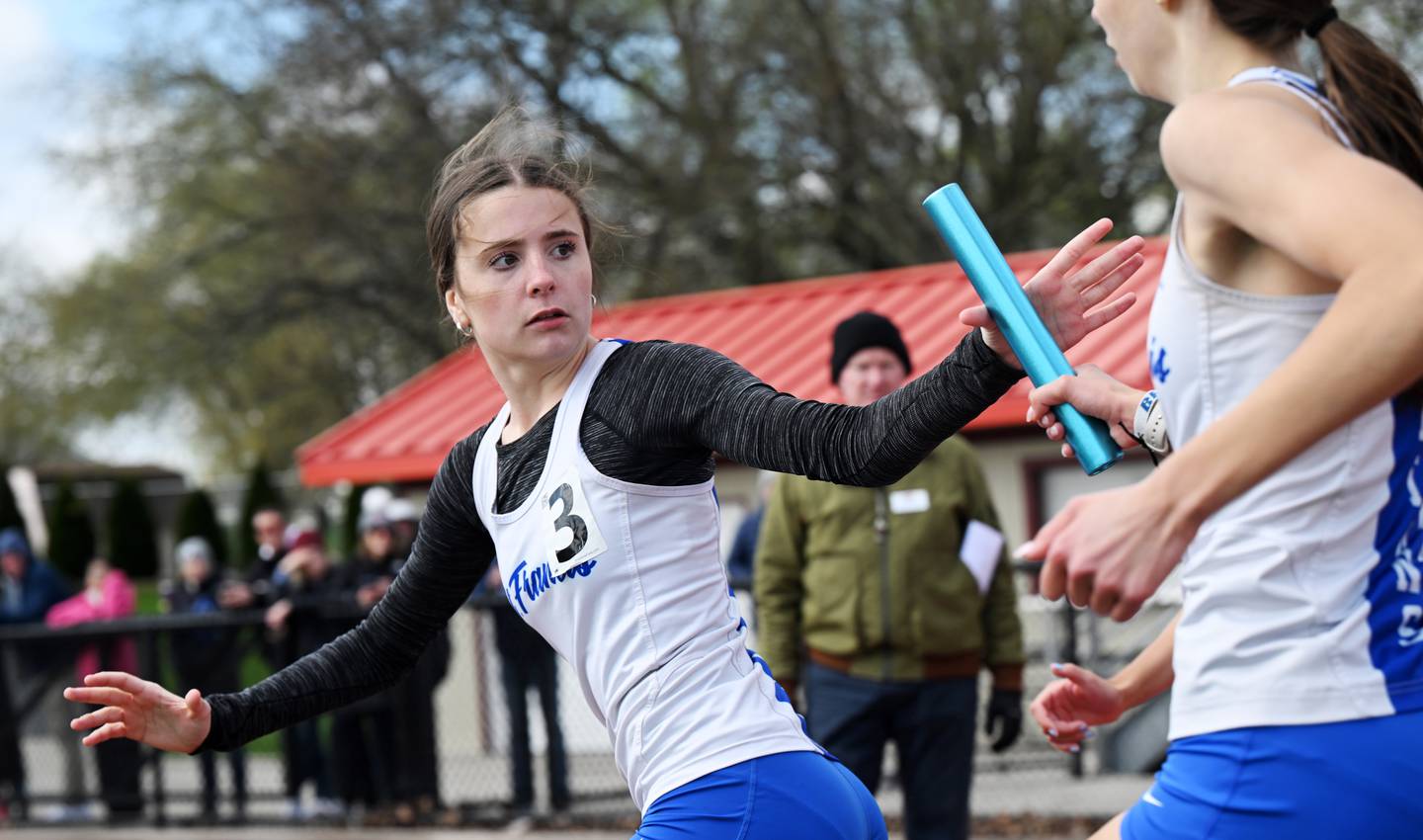 St. Francis anchor Erin Hinsdale takes the baton from teammate Margaret Andrzejewski in the 3,200-meter relay during the Schaumburg girls track and field invite on Saturday, April 18, 2026.