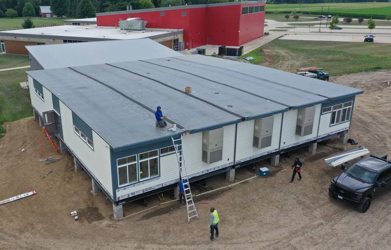 Crews install four 70 x 70 modular classrooms on the new property next to Waltham School on Monday, July 8, 2024 in Utica. The school, built in 2018, has already outgrown its 240 student capacity and placed the four classrooms next to the school.