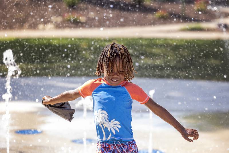 Ja’myrin Jones, 6, finds the coolest spot in Sterling Wednesday, August 23, 2023 at the splash pad in Grandon Park. Temps reached triple digits Thursday on another sweltering day.